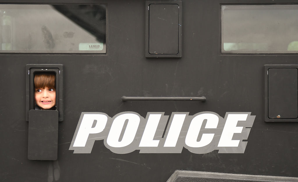 Antonio Campbell, 7, peeks out from an armored police vehicle for the sensory-friendly Touch-a-Truck event